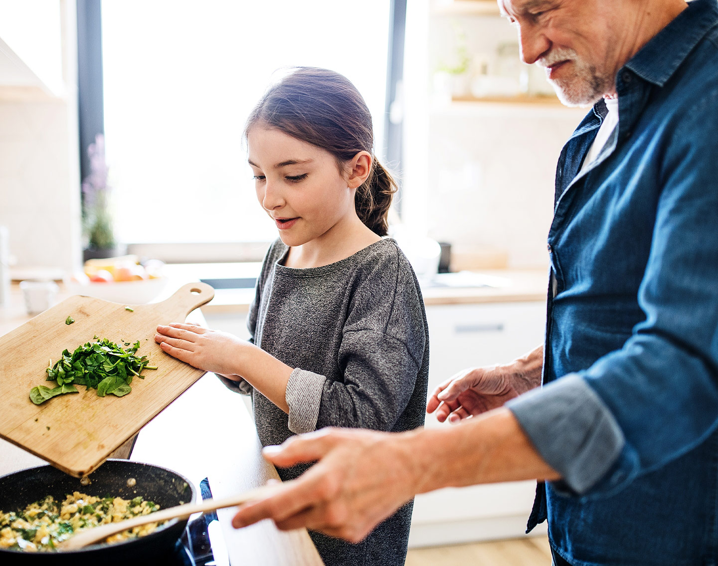 Girl and granfather in kitchen cooking